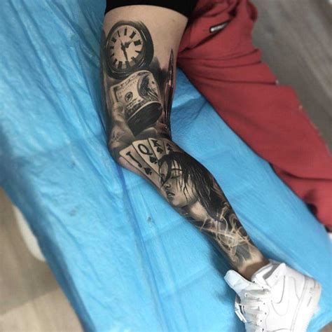 A Person With A Tattoo On Their Arm And Leg Sitting On A Blue Sheet