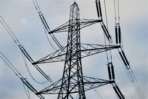 Une ligne électrique à haute tension contre un ciel nuageux photo