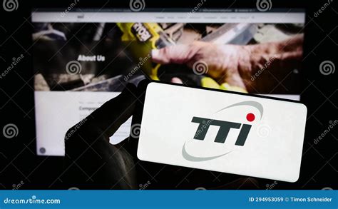 Person Holding Smartphone With Logo Of Techtronic Industries Company