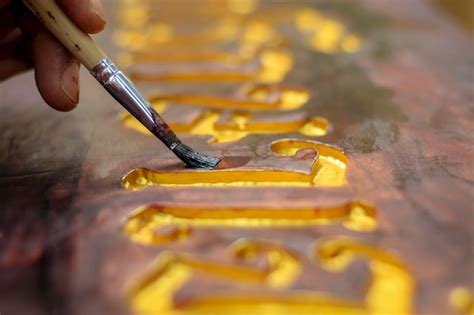 Premium Photo Close Up Of A Mans Hand Holding A Golden Paintbrush