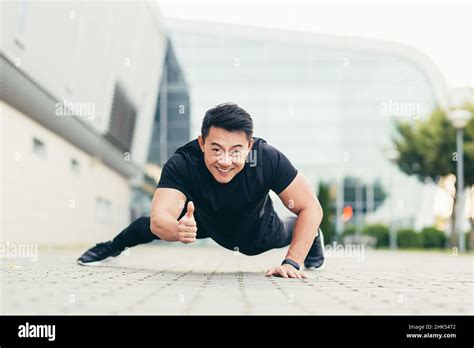 Asian Athlete Performs Sport Pushing Off The Ground Looks At The Camera