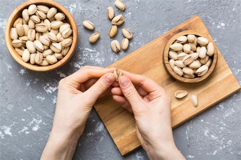 Premium Photo Woman Hands Holding A Wooden Bowl With Pistachios Nuts