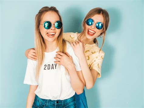 Zwei junge schöne lächelnde blonde hippie mädchen in der bunten kleidung des modischen sommers