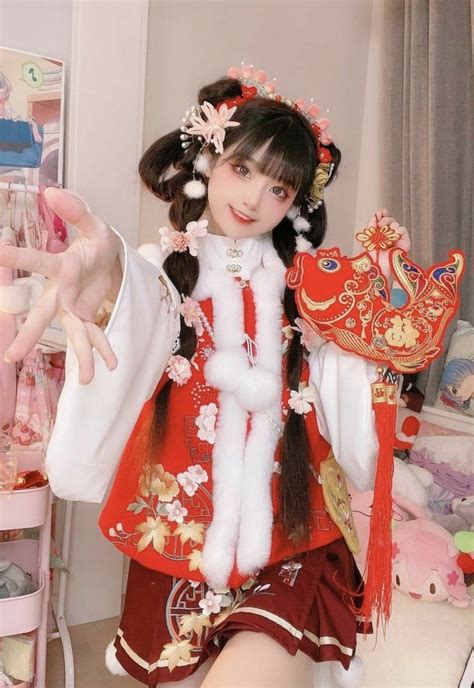 A Woman In A Red And White Costume Holding Up A Fan