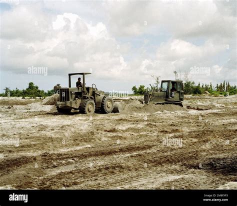 Seabees Use A Front Loader Left And A Bulldozer To Consolidate Piles