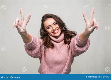 Portrait Of A Smiling Happy Woman Showing Victory Sign And Looking At