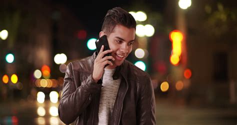 Millennial Hispanic Man Standing On City Bridge At Night Looking At