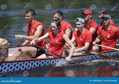 Crew Of Young Men And Women Rowing The Dragon Boat On The River