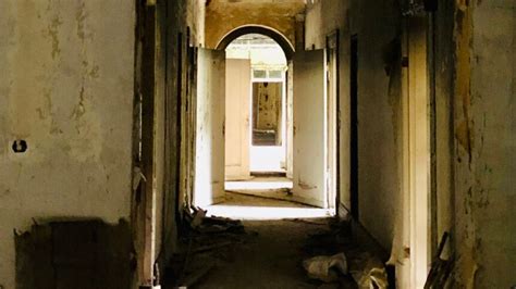 An Old Hallway With Peeling Paint On The Walls