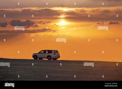 Toyota Landcruiser 4wd Driving Through Dunes At Sunset Time Dune Bashing As Part Of A Desert