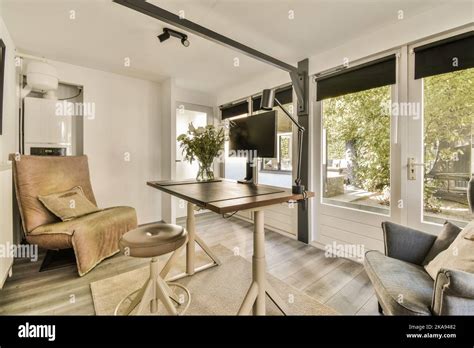 Interior Of Light Home Office With Desk And Shelf Rack Near Window With