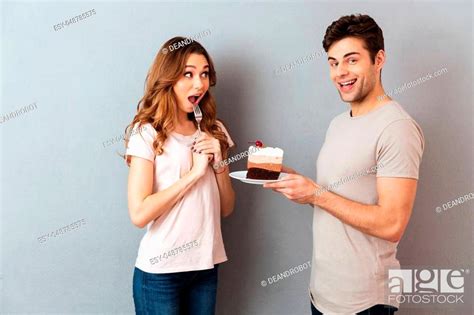 Portrait Of A Happy Man Giving His Girlfriend A Piece Of Cake On A