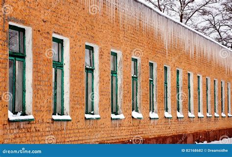 Icicles Hanging From The Roof Of The Old Brick Building Stock Photo