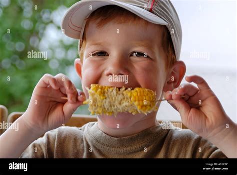 Little Boy Is Eating A Barbecue Corn Cob Stock Photo Alamy