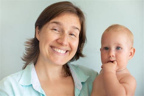 Cute Infant Baby On Mothers Hands On A Gray Background Mother Hugging