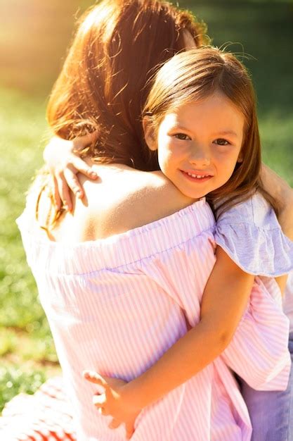 Premium Photo Back View Of Girl Hugging Her Mother And Looking At The