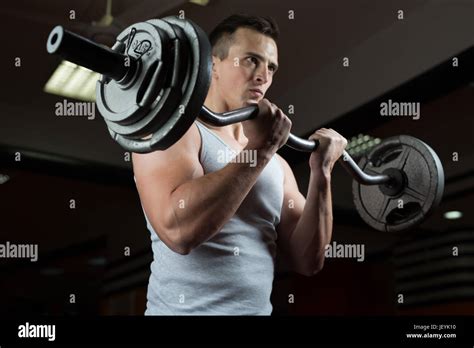 Closeup Portrait Of A Muscular Man Workout With Barbell At Gym