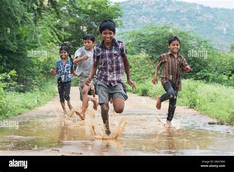 Rural Indian Village Children Running Through A Muddy Puddle Andhra