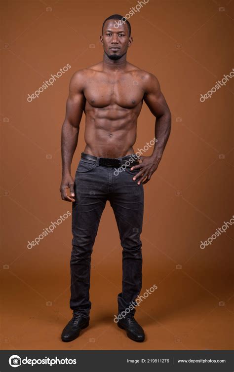 Handsome Muscular African Man Shirtless Against Brown Background Stock