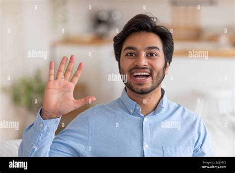 Happy Man Waving Hello In A Casual Setting Stock Photo Alamy