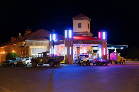 Old Roadside Gas Station With Vintage Cars Exposed At Night Editorial