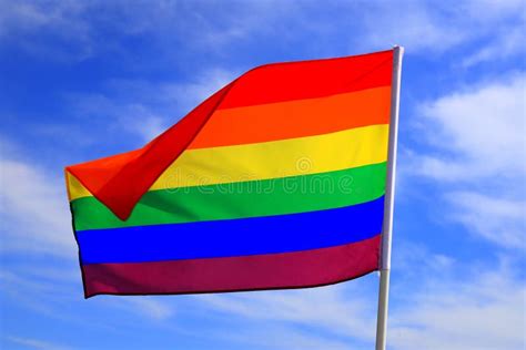 Realistic Rainbow Flag Of Lgbt Organization Waving Against A Blue Sky