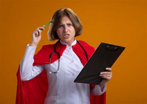 Confus Jeune Femme Super héros Blonde En Cape Rouge Portant L uniforme Du Médecin Et Un