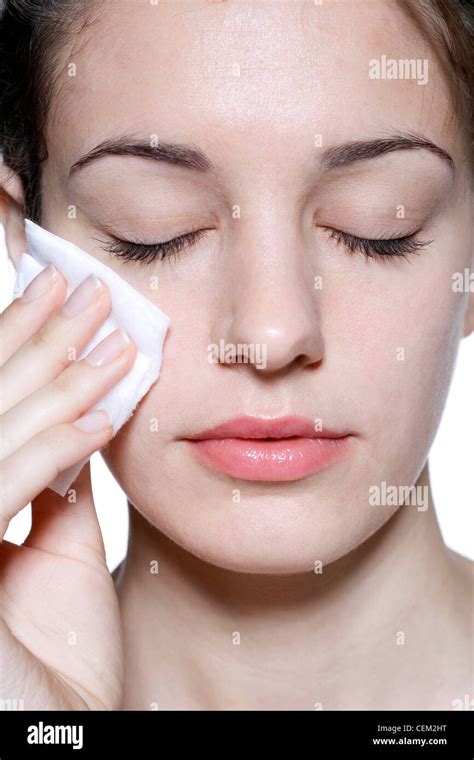 Female With Brunette Hair Off Her Face Rubbing Cheek With Cosmetic