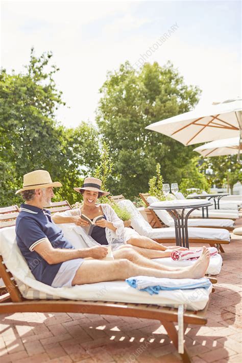 Mature Couple Relaxing At Resort Poolside Stock Image F024 9288
