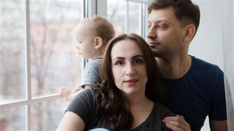 Mother Father And Baby Sitting By A Window