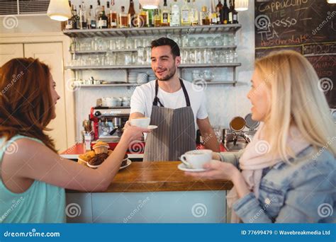 Happy Barista Serving Coffee To Female Customer At Cafe Stock Image