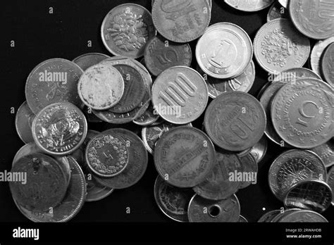 A collection of international coins and currency in a black and white ...