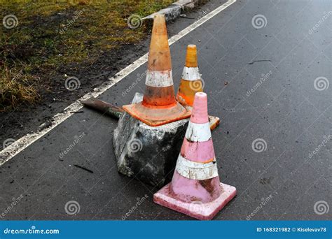 Old Dirty Traffic Cones On The Wet Asphalt At The Edge Of The Road