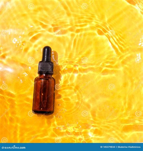 Essential Oil in Water on a Yellow Background. the Concept of