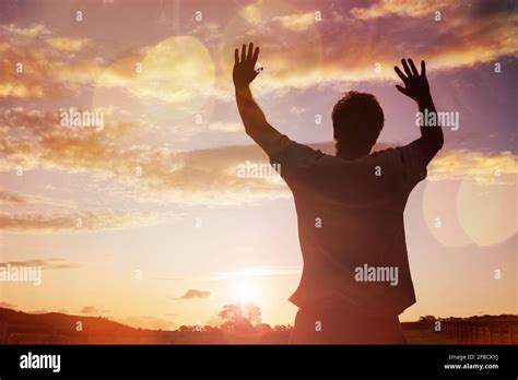 Silhouette Of A Man With Hands Raised In The Sunset Concept For