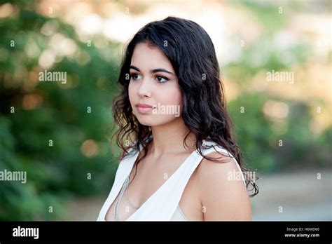Beautiful Brunette Girl Relaxing In The Park Wiht Many Plants Of