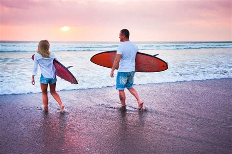 Couple Of Surfers Walking On Coast In Indonesia Stock Image Image Of