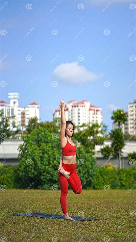 Asian Chinese Female Lady Yogi Practise Yoga Stretches Poses In The Park In Beautiful Weather