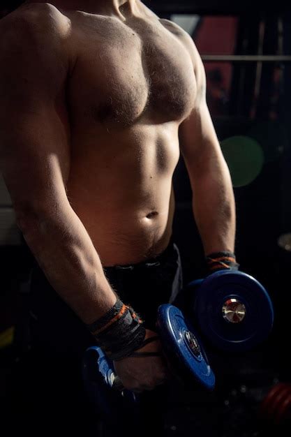 Premium Photo Midsection Of Shirtless Man Lifting Dumbbells