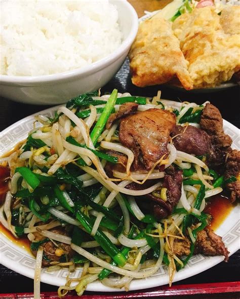 A White Plate Topped With Meat And Veggies Next To Rice