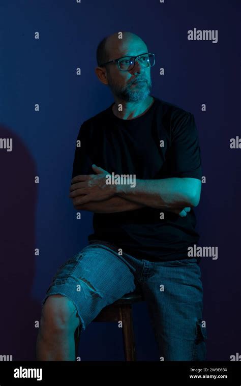 Portrait Of Bearded Bald Man Wearing Prescription Glasses Sitting On