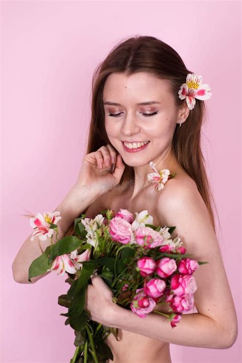 Naked Skinny Girl Holding Flowers On A Pink Background Brunette Stock