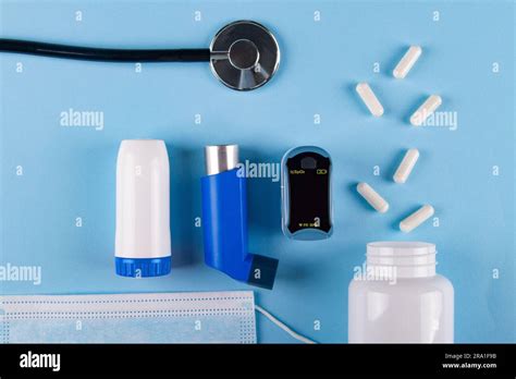 Top view of medical mask, stethoscope, oximeter, bottle of pills and ...