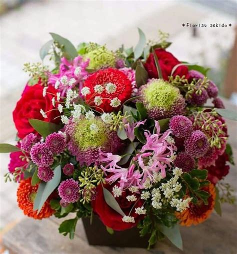 A Bouquet Of Flowers Sitting On Top Of A Wooden Table