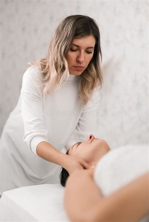 Attentive Cosmetologist Doing Massage To Female Client Stock Image