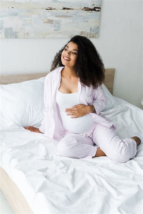 View Of Happy Curly Pregnant African American Woman Touching Belly