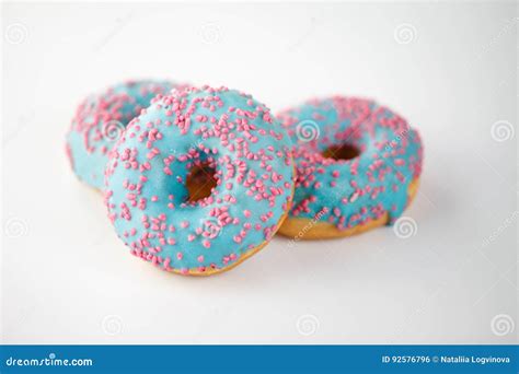 Donuts With Blue Glaze And Pink Sprinkles On White Background Top View