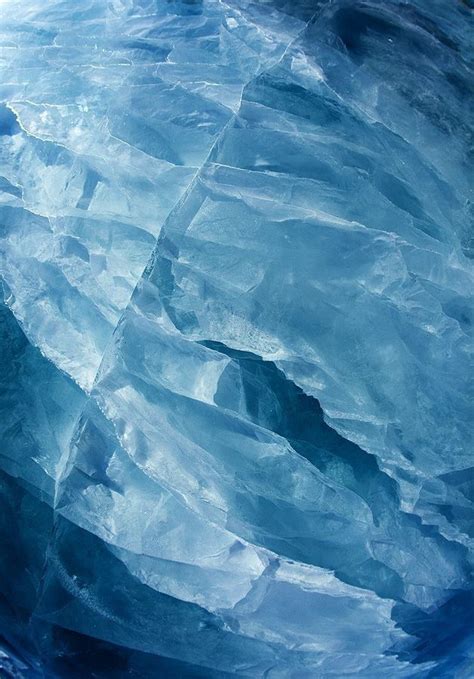 An Iceberg Is Shown In The Water With Blue Hues And White Snow Flakes