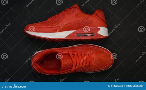 Close Up Red Sneakers With White Sole On A Black Background Stock