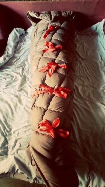 A Sleeping Bag On Top Of A Bed Covered In Blankets And Red Ribboned Ties